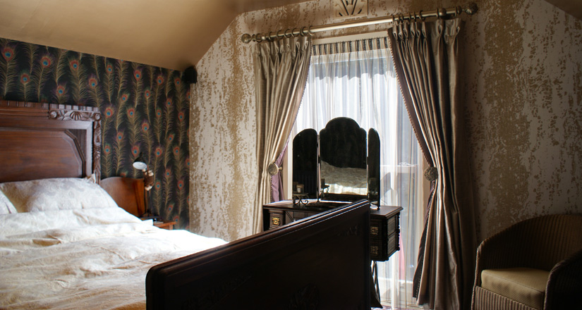 Art deco style bedroom with Sanderson & Harlequin wallpapers, goblet-pleat curtains with contrast lining and beaded trim, gathered sheers, Sanderson bedcovers, vintage (1880s - 1950s) furniture.